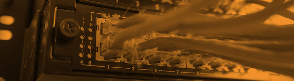 Close-up of ethernet cable ports in an orange-tinted rack — banner imagery from the FHG homepage What-If? carousel, 2015-2017.