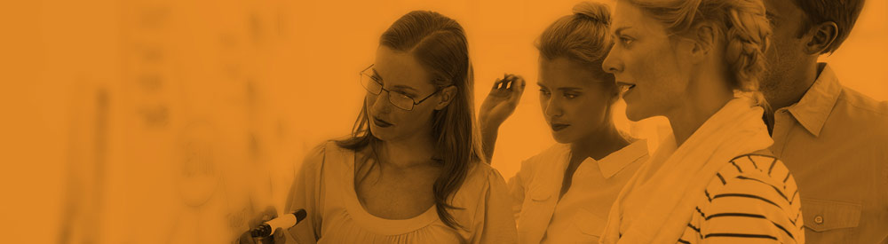 Orange-tinted photo of four women at a whiteboard — banner imagery from the FHG homepage What-If? carousel, 2015-2017.